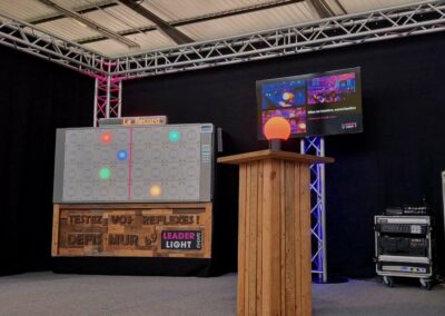 Animation mur digital réflexe Leader Light Events sur un stand événementiel avec structure de scène en aluminium et écran de contrôle.